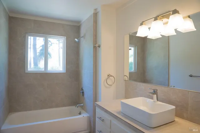 a bathroom with a bathtub a sink and a mirror