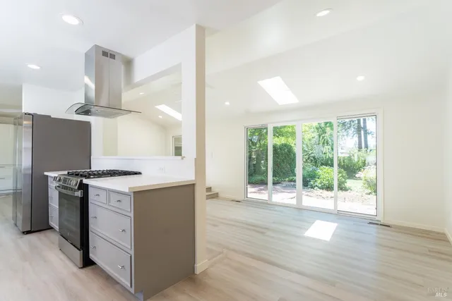 an open kitchen with a stove and wooden floor