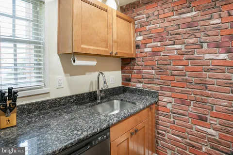 a kitchen with granite countertop a sink and a window