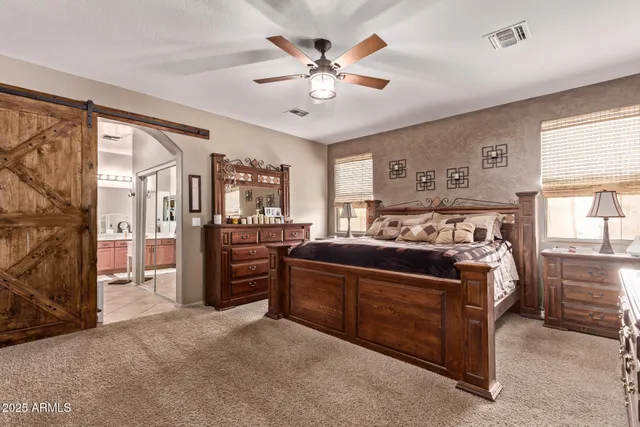 a bed room with a bed and a ceiling fan