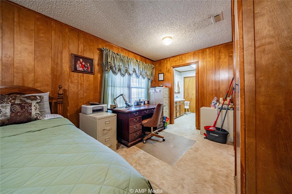 1992 Sand Flat Road Jacksboro, TX 76458 - Photo 31 of 36 Carpeted bedroom featuring wooden walls and a textured ceiling
