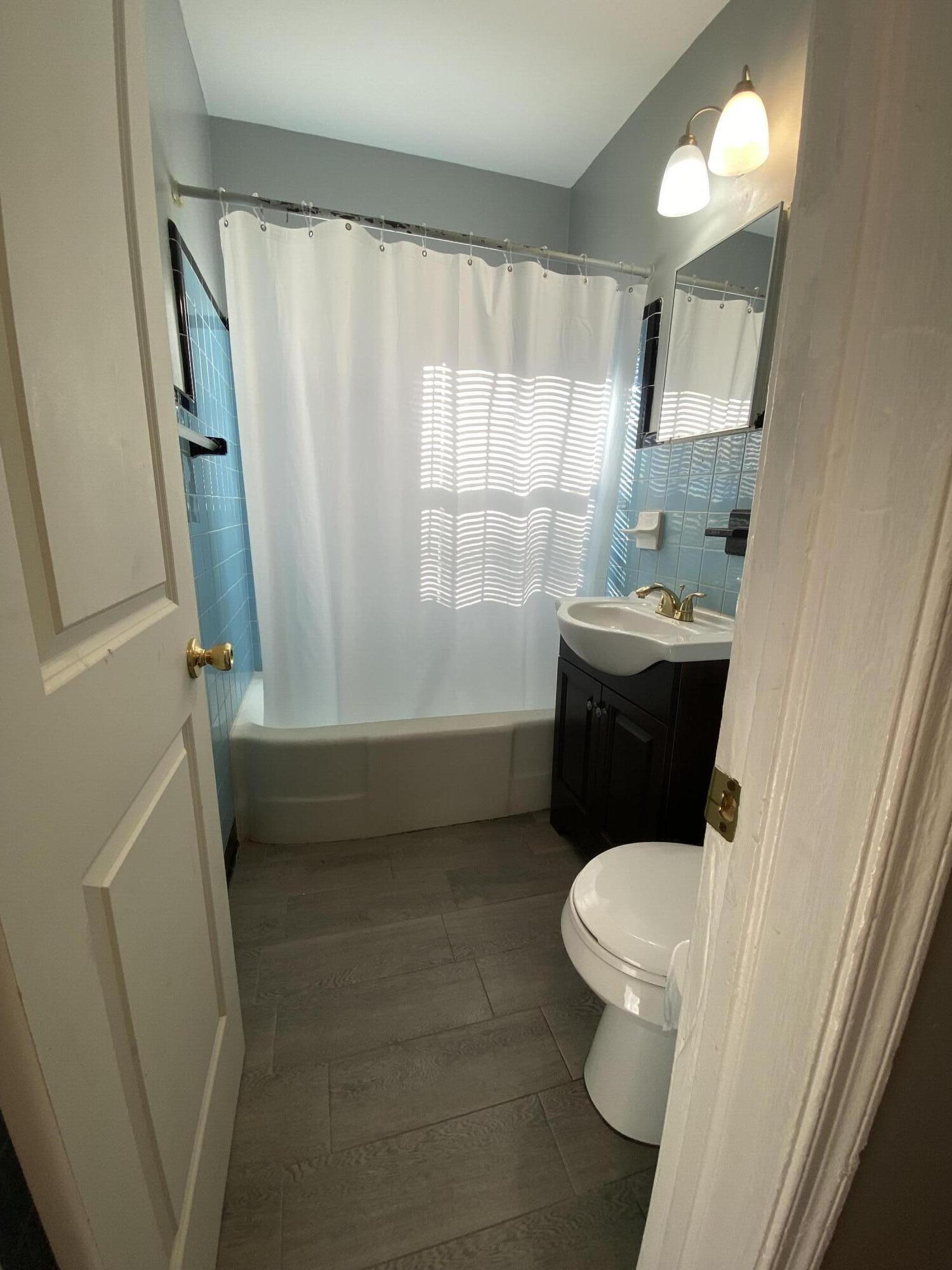 119 West 25th Street, Unit B Riviera Beach, FL 33404 - Photo 3 of 7 a bathroom with a sink a toilet a tub and shower