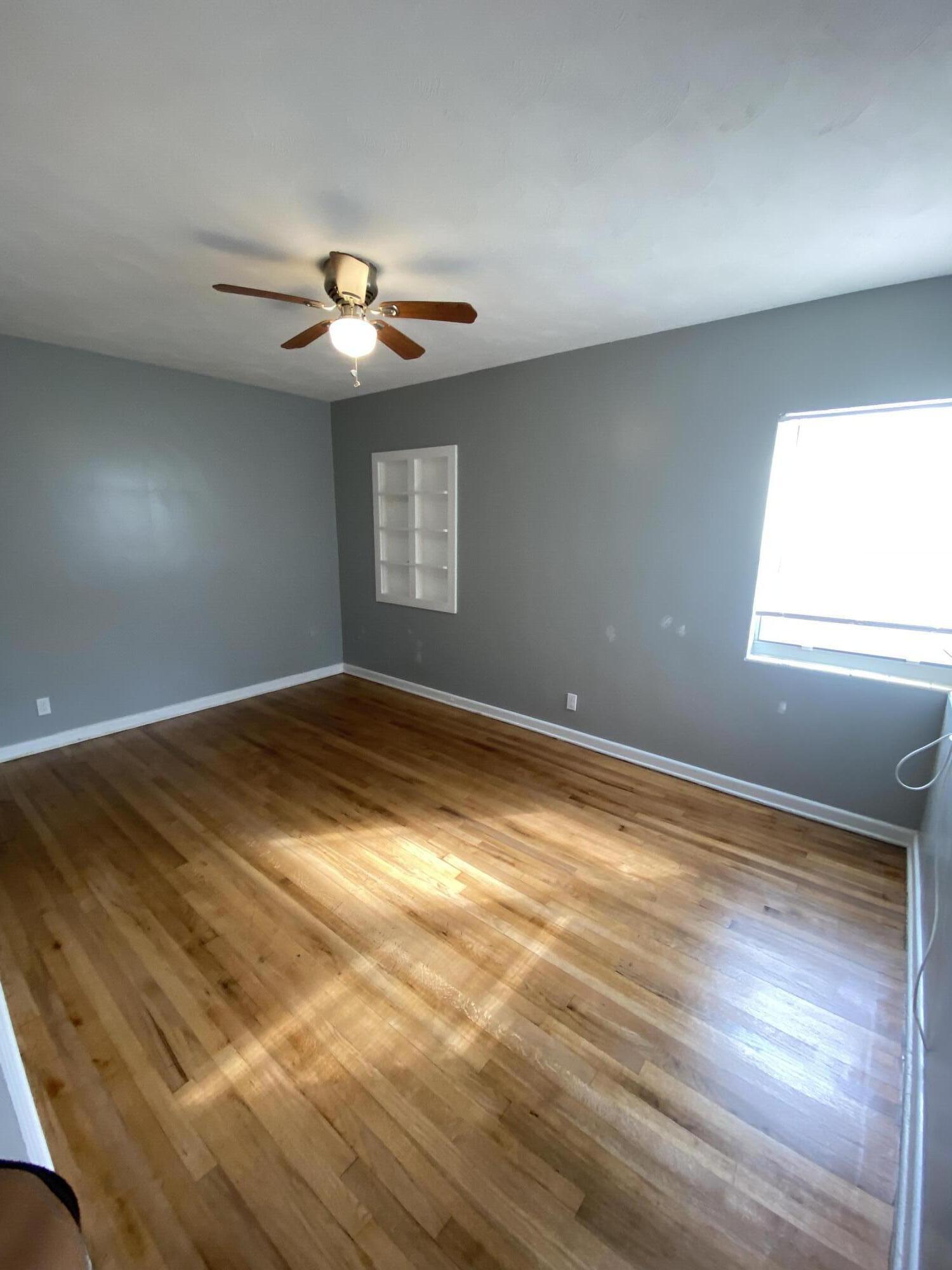 119 West 25th Street, Unit B Riviera Beach, FL 33404 - Photo 4 of 7 wooden floor in an empty room with a window