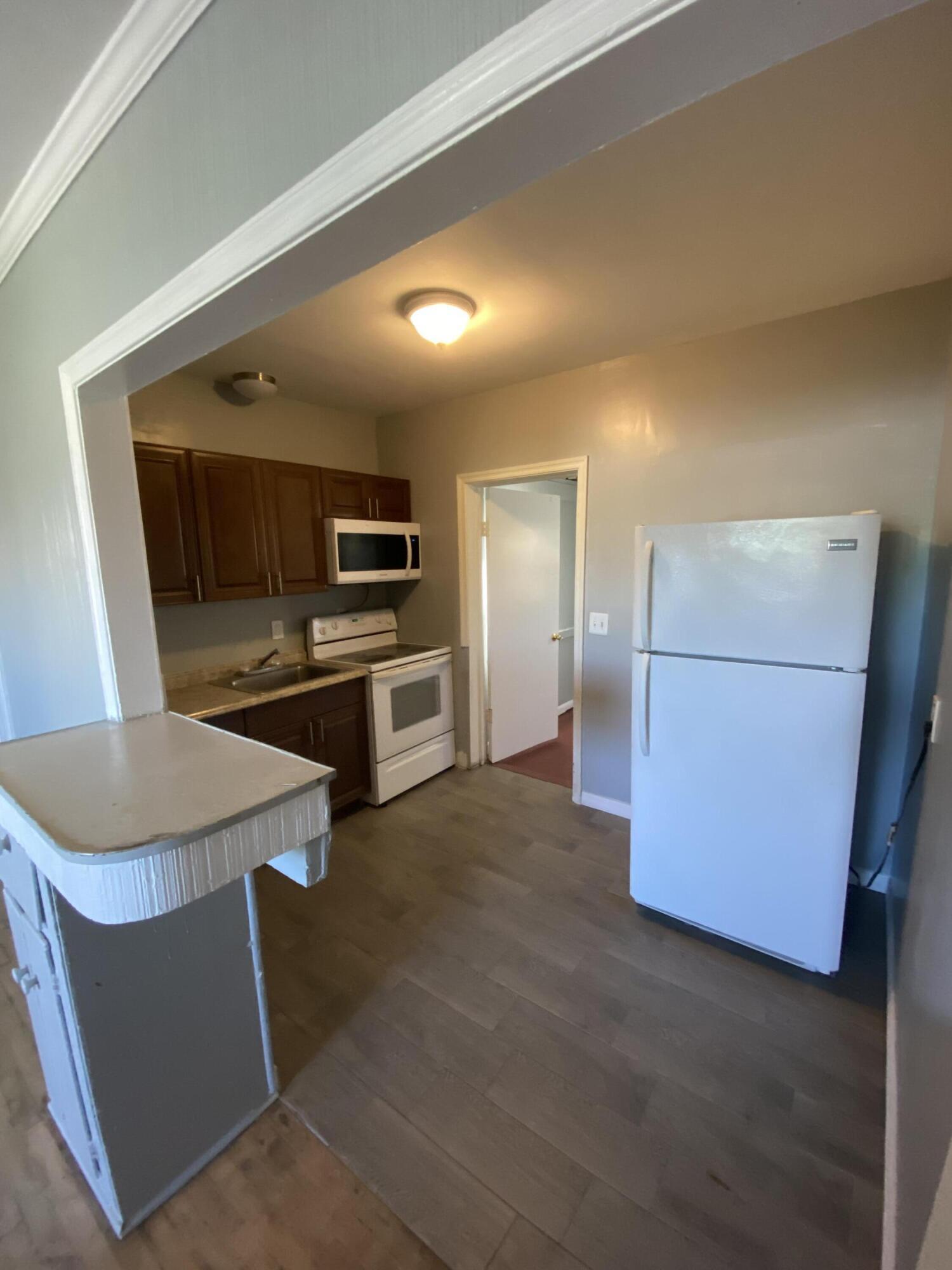 119 West 25th Street, Unit B Riviera Beach, FL 33404 - Photo 7 of 7 a kitchen with sink and refrigerator