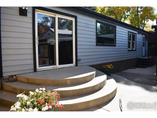 a view of a house with chairs and potted plants