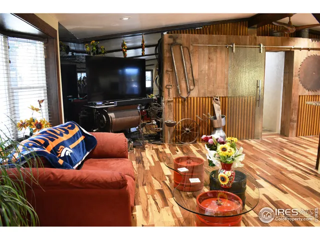a view of a patio with table and chairs potted plants and floor to ceiling window