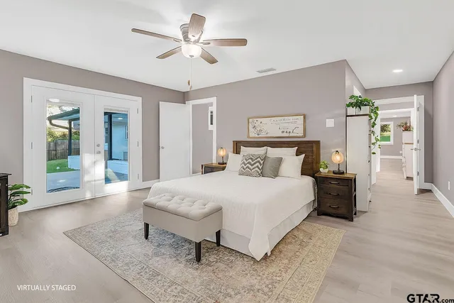 a spacious bedroom with a bed and a chandelier