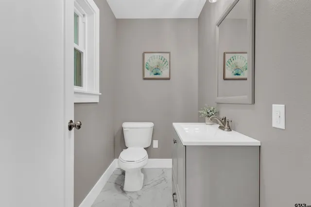 a bathroom with a toilet sink and mirror