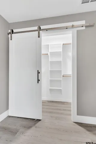 a view of walk in closet with empty racks