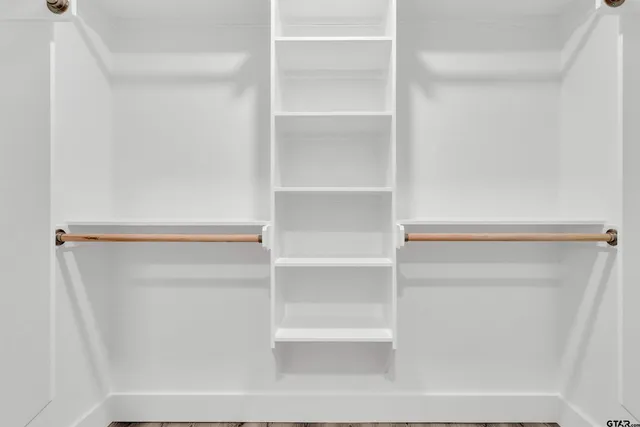a view of walk in closet with empty racks