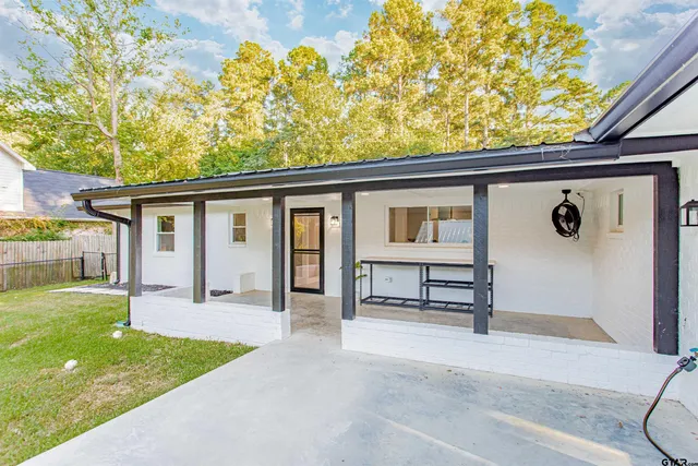 a view of a house with a backyard and a tree