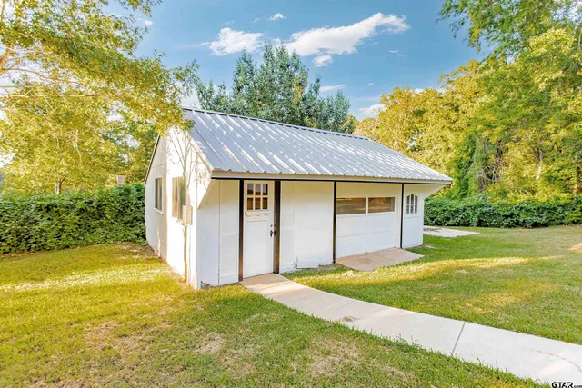 a front view of house with yard and trees
