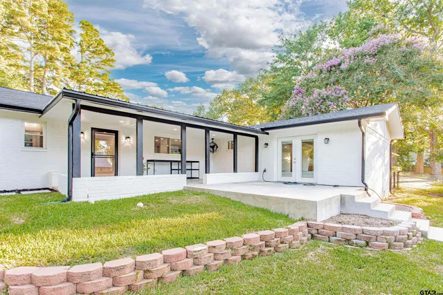 a front view of a house with garden and yard