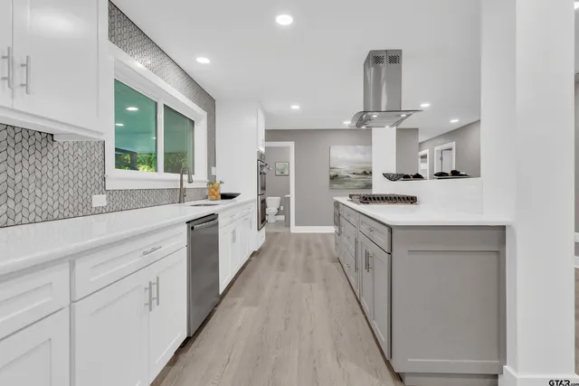 a kitchen with stainless steel appliances a sink stove and cabinets