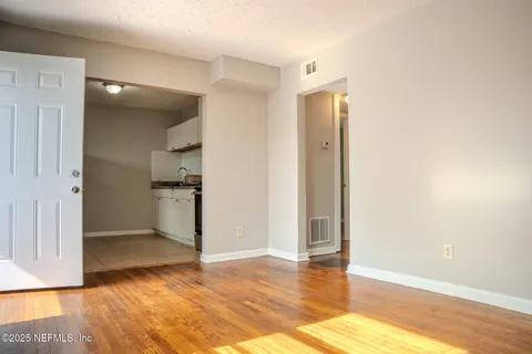 a view of empty room with wooden floor