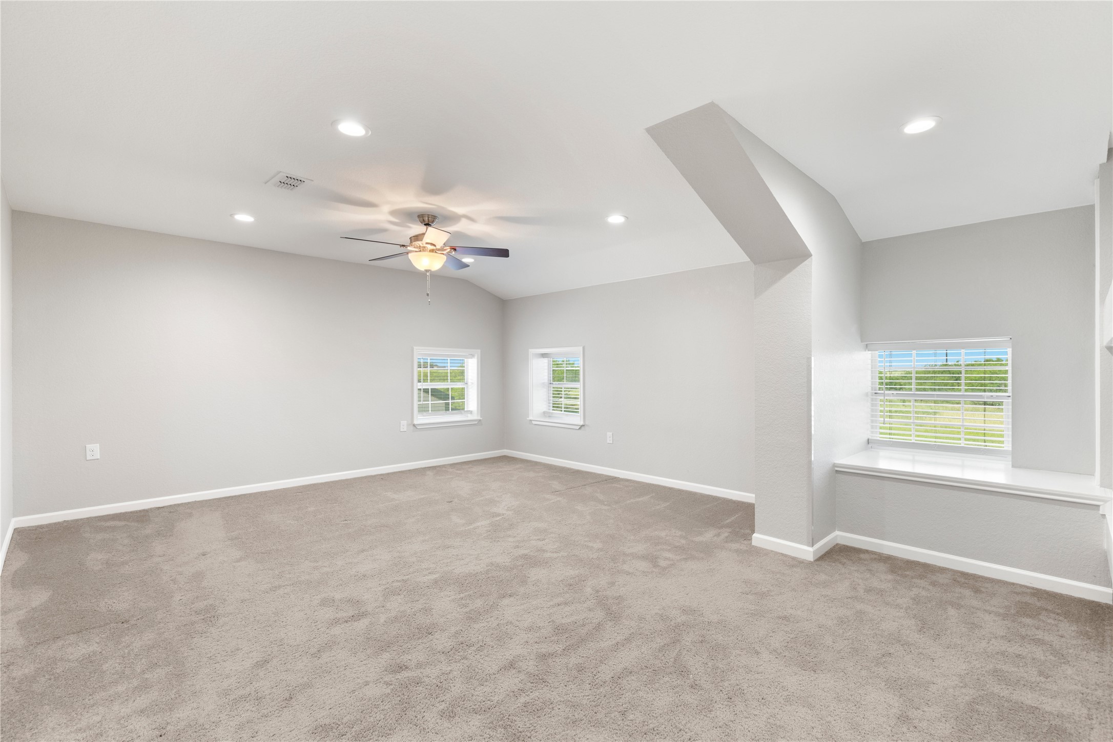 1293 Pioneer Road Seguin, TX 78155 - Photo 33 of 40 A generously proportioned bedroom features recessed lighting and a ceiling fan, with serene outdoor views from multiple windows.