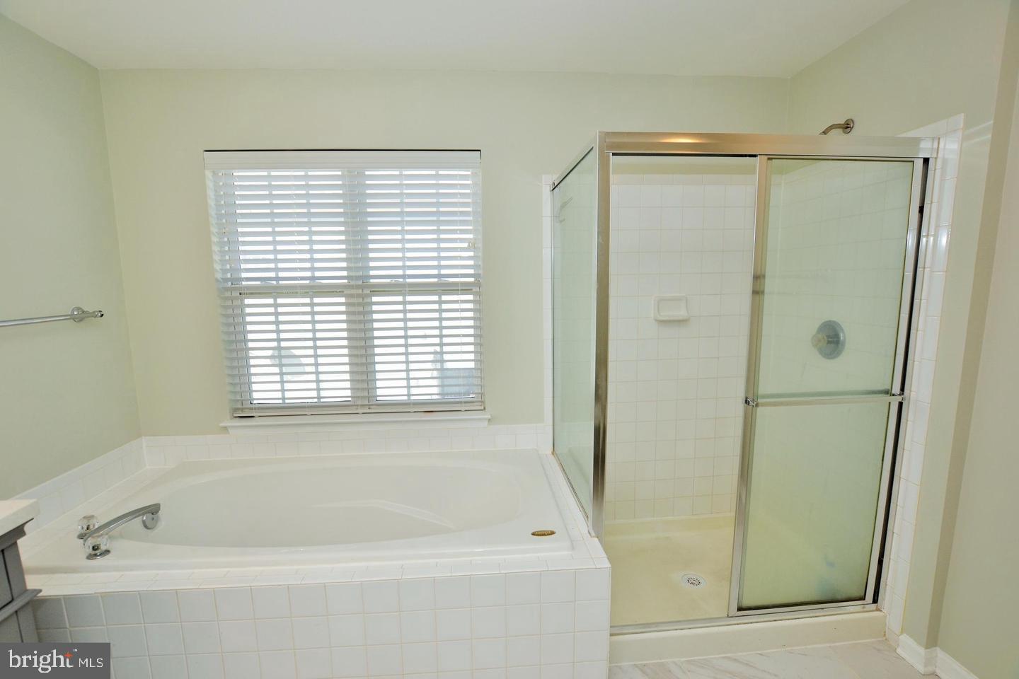 43048 Zander Terrace Ashburn, VA 20147 - Photo 11 of 18 a bathroom with a bathtub a shower and a window