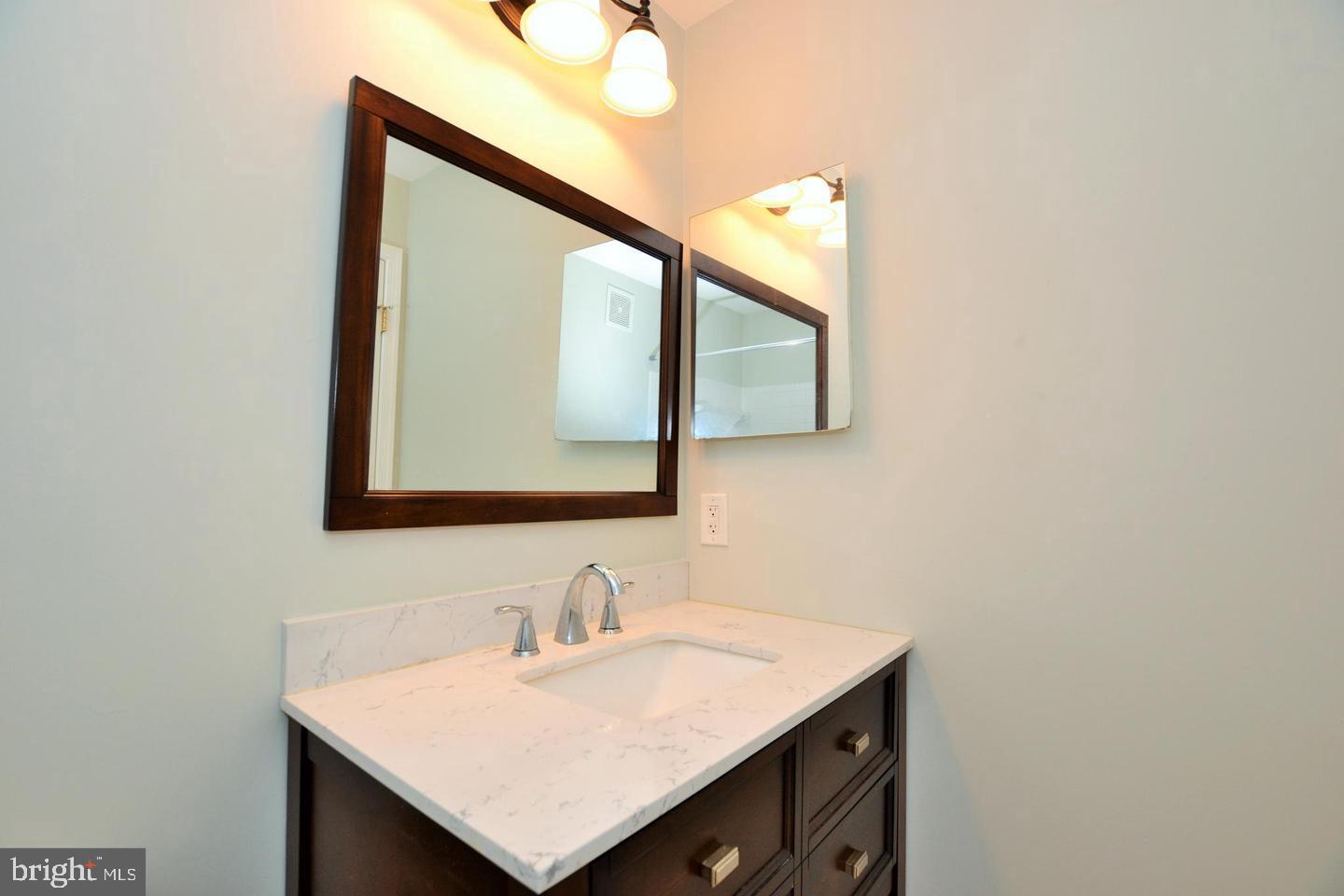 43048 Zander Terrace Ashburn, VA 20147 - Photo 15 of 18 a bathroom with a sink vanity and a mirror