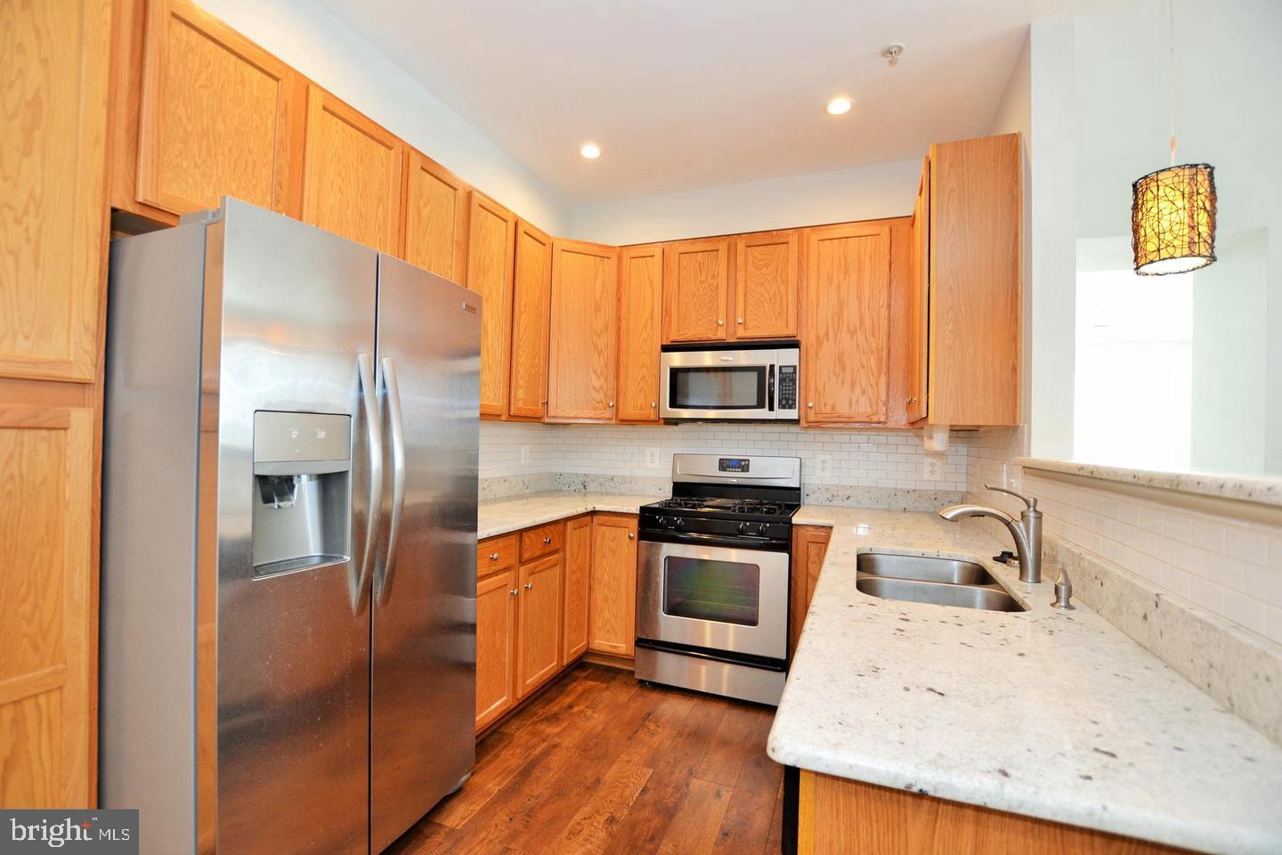 43048 Zander Terrace Ashburn, VA 20147 - Photo 2 of 18 a kitchen with stainless steel appliances granite countertop a refrigerator stove and sink