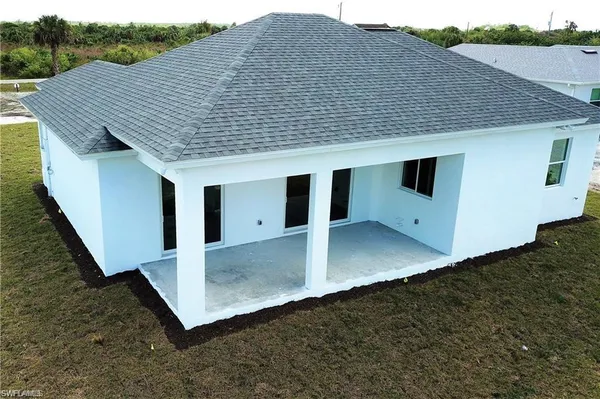 a view of a white house next to yard