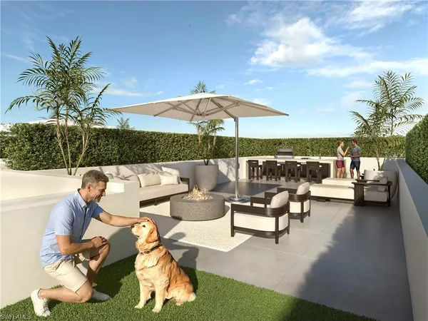 a view of a patio with couches table and chairs under an umbrella with a fire pit