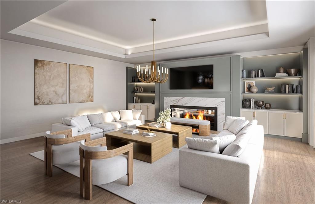 210 9th Street South, Unit 301 Naples, FL 34102 - Photo 5 of 6 a living room with furniture a flat screen tv and a fireplace