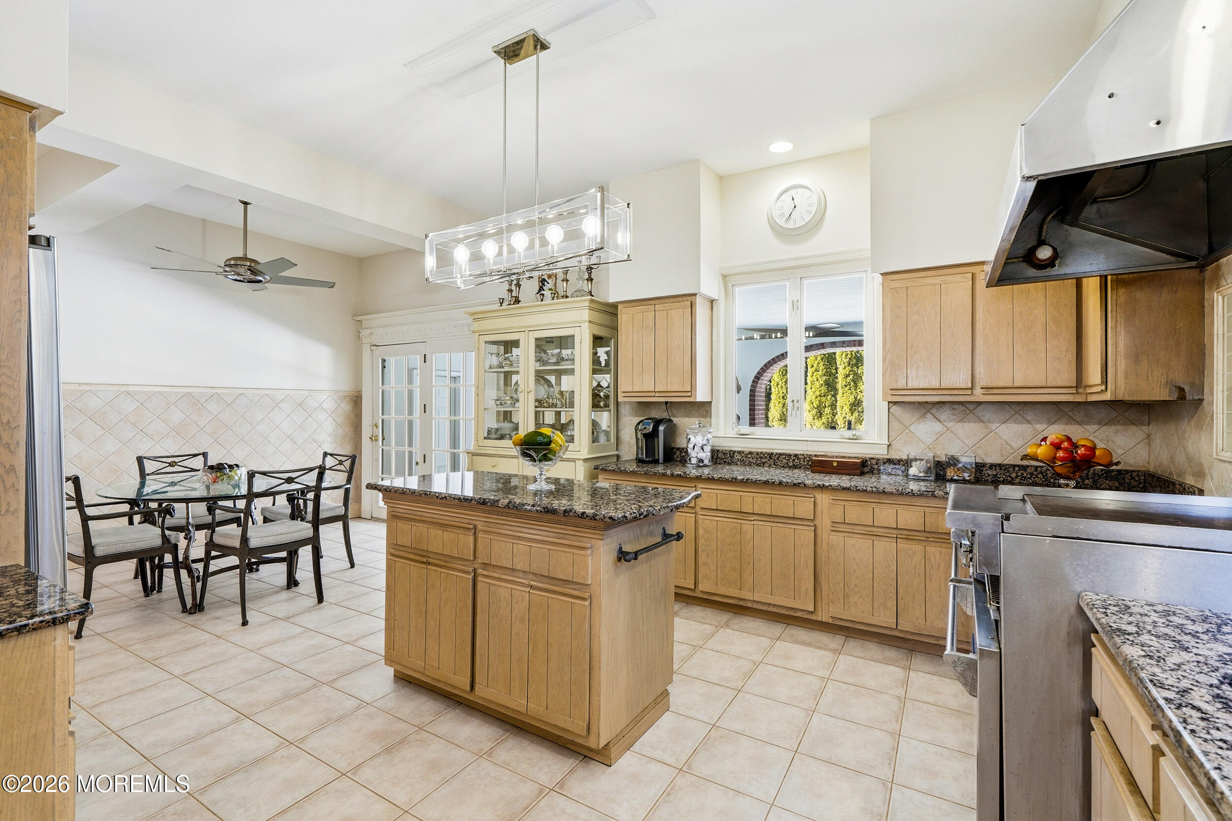 3 Elberon Square Long Branch, NJ 07740 - Photo 11 of 22 a kitchen with stainless steel appliances granite countertop a stove top oven a sink a dining table and chairs with wooden floor
