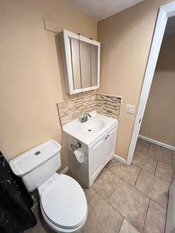 a bathroom with a sink toilet and mirror