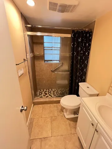 a bathroom with a toilet and a shower