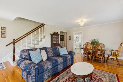 a living room with furniture a table and wooden floor