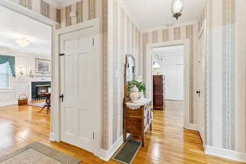 a view of a hallway with dining room and wooden floor