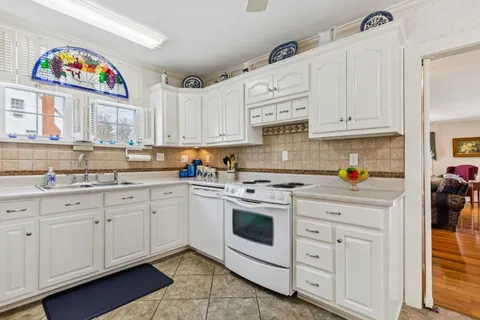 a kitchen with granite countertop white cabinets and white appliances