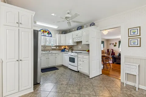 a kitchen with granite countertop cabinets and white stainless steel appliances