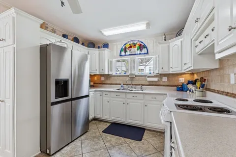 a kitchen with stainless steel appliances granite countertop a refrigerator and a stove top oven