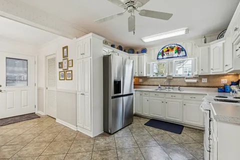 a kitchen with granite countertop a refrigerator and a sink