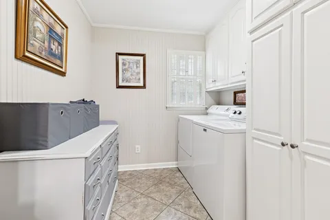 a utility room with cabinets washer and dryer