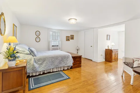 a bedroom with a bed and wooden floor