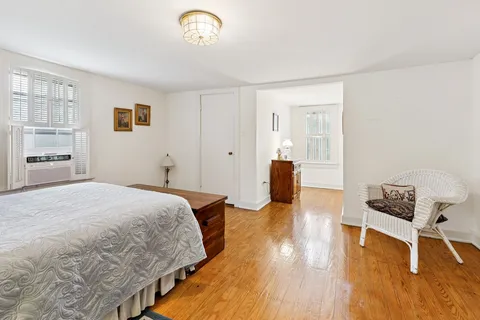 a spacious bedroom with a bed and a chair in it