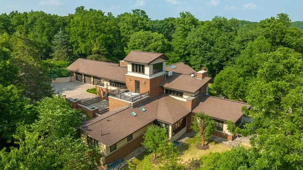 an aerial view of a house with a yard and trees