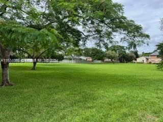 11545 Southwest 109th Road, Unit 25W Miami, FL 33176 - Photo 2 of 16 a view of a grassy field with benches