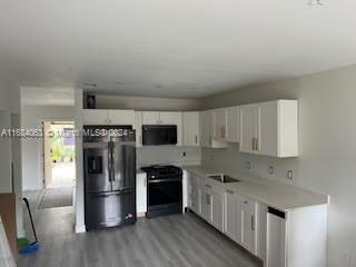 11545 Southwest 109th Road, Unit 25W Miami, FL 33176 - Photo 6 of 16 a kitchen with refrigerator a sink and wooden floor