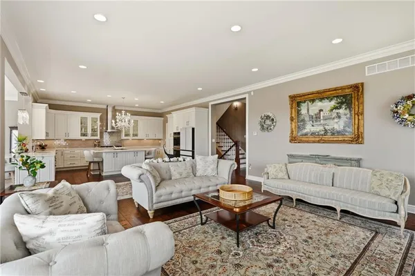 a living room with furniture a rug and kitchen view