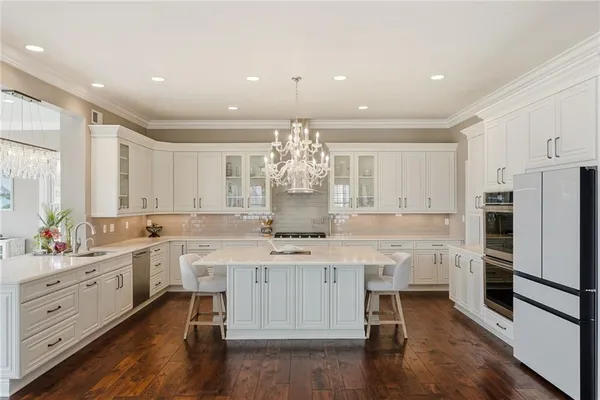 a kitchen with kitchen island a sink stainless steel appliances and cabinets