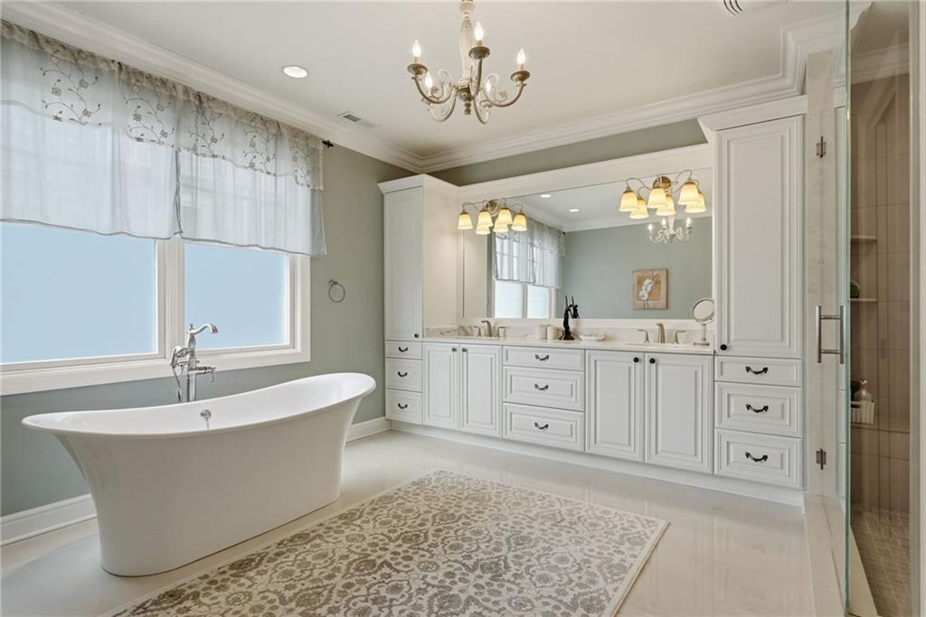1690 Shelburne Lane Pittsburgh, PA 15217 - Photo 27 of 50 a spacious bathroom with a double vanity sink a mirror a bathtub and next to a window