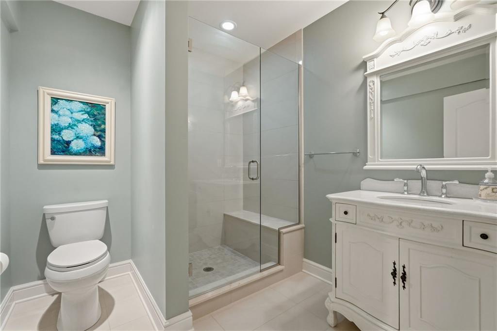 1690 Shelburne Lane Pittsburgh, PA 15217 - Photo 44 of 50 a bathroom with a toilet a sink a glass door a shower a mirror and vanity