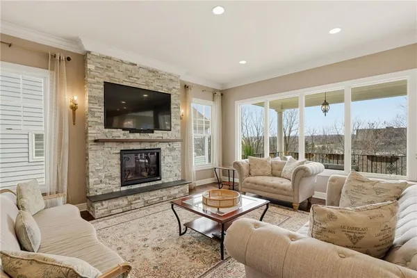 a living room with furniture a flat screen tv and a fireplace