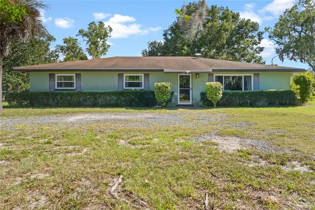 a front view of a house with a yard and potted plants