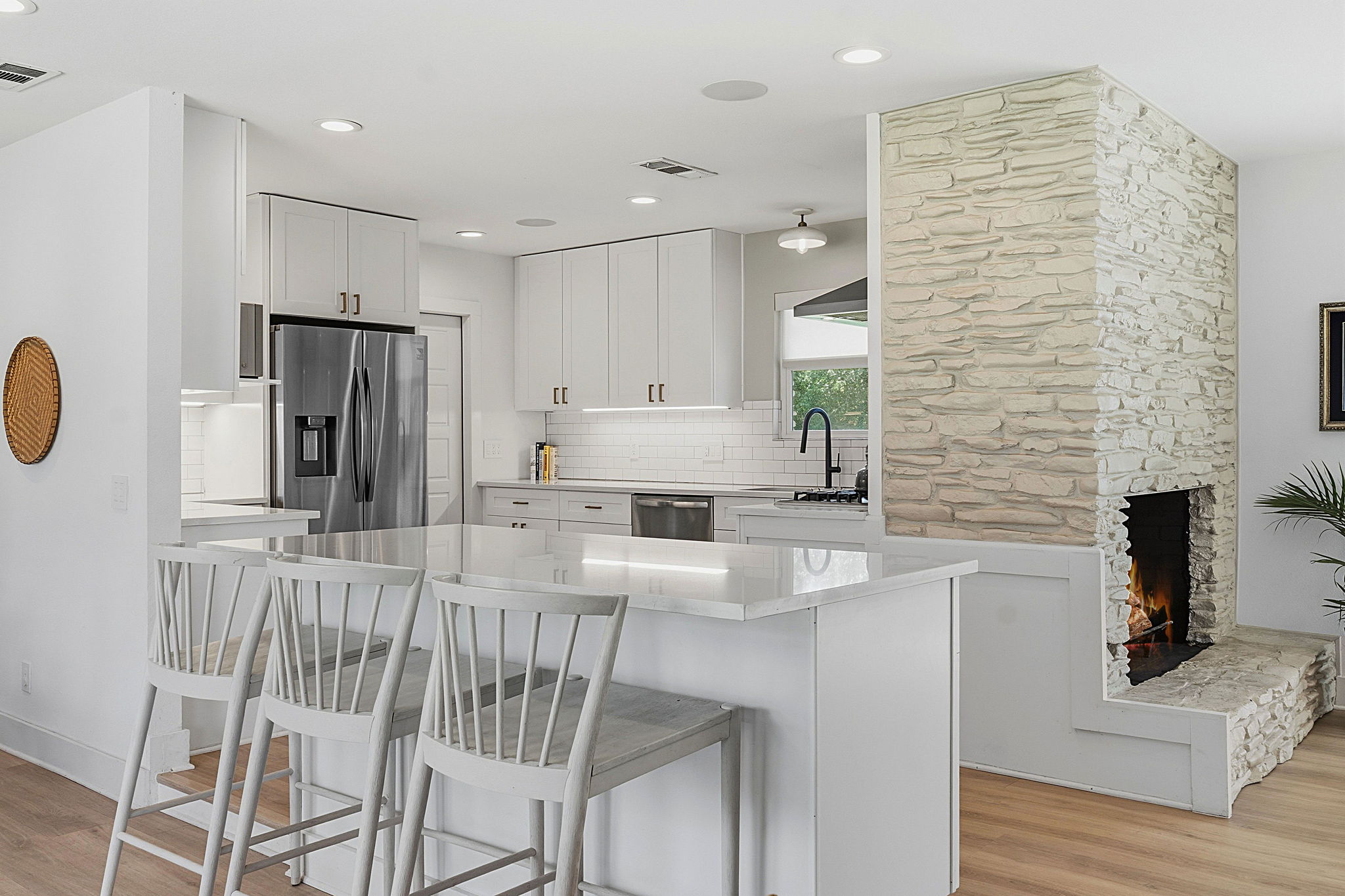 4403 Elmsgrove Drive Austin, TX 78721 - Photo 25 of 38 A contemporary kitchen space boasts a large island with seating and a striking stone fireplace feature.