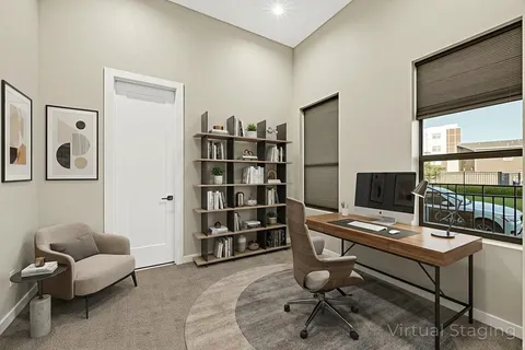 a view of a workspace with furniture and a window