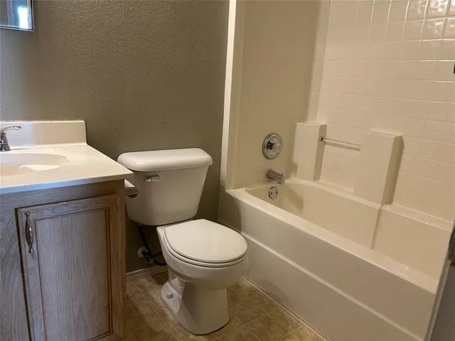 a white toilet sitting next to a bath tub